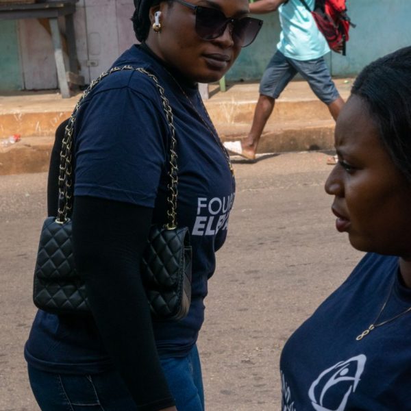 Two Foundation Elevators volunteers walking through Abiriw township on distribution day