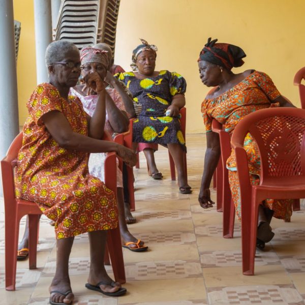 Widows seated in the community centre waiting for the distribution to begin