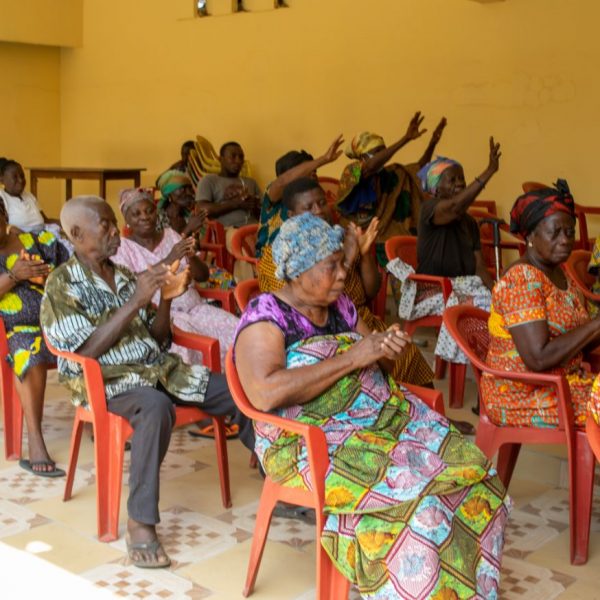 Beneficiaries raising their hands during the community address