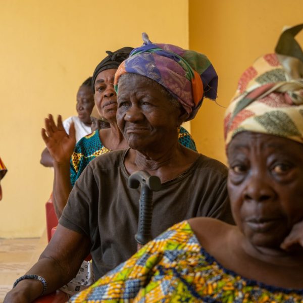 A widow in a head wrap listens to the opening address