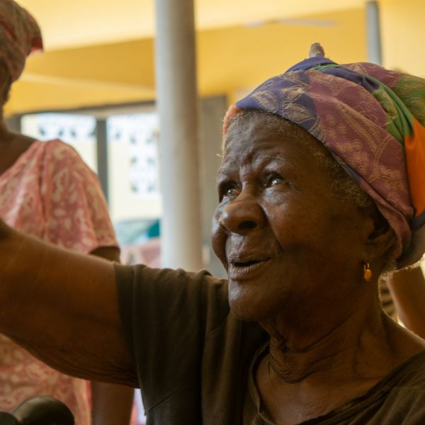 A widow lifts her hand during the Widows in Need gathering