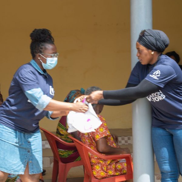 Two volunteers handing over a food parcel