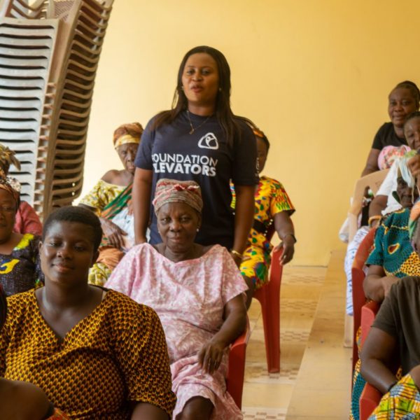 A group of beneficiaries photographed with a Foundation Elevators volunteer
