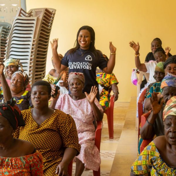 Beneficiaries raising their hands in celebration at the close of the programme