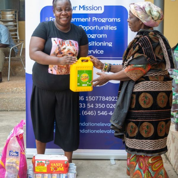 A beneficiary receiving her supplies in front of the Foundation Elevators banner