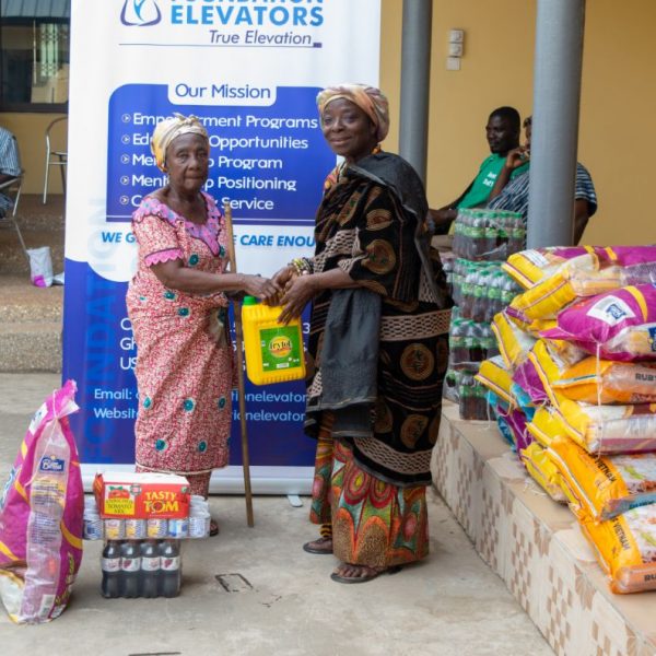 A widow standing with her allocation of food supplies