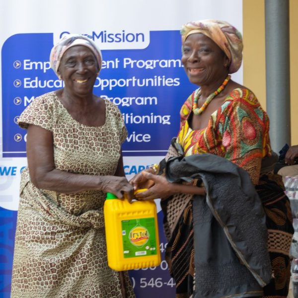 A widow receiving her supplies at the Foundation Elevators banner