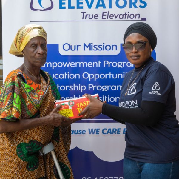 A widow receiving her parcel in front of the organisation banner